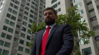 Şehir merkezinde lüks kıyafetler içinde başarılı bir orta yaşlı işadamı iş görüşmesini bekliyor. İş ortaklarıyla iş görüşmesi, iletişim ve başarı için saatine bakıyor.