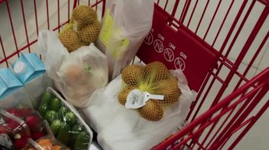 Süpermarketteki bir tramvayda yakın çekim yapacağız. Bir kadının eli bakkaliyeye alışveriş poşeti koyar.