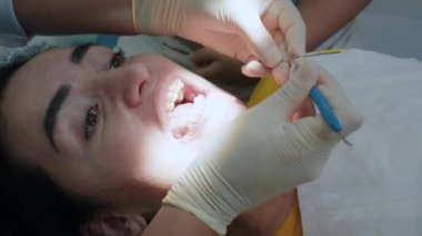 Kadın doktor hastanın kolyeye mühür takmasını, güzel bir gülümseme takmasını diş teli takmasını diş, diş ipi, diş teli kullanmasını tartışıyor. Kadınlar ortodontiktir. Diş sağlığı, diş hekimliği..