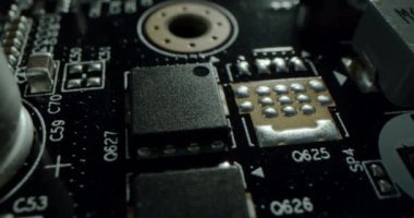 Macro dolly shot side view of a computer electrical circuit with cip, slots, microchip and microprocessors, black board with transistors and microchips. Close up detail of electronic components on PC