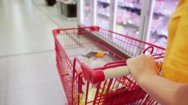 Pembe takım elbiseli çekici genç kadın lahana salatası seçiyor, süpermarketten alışveriş yapıyor, bakkaldan sağlıklı yiyecekler alıyor, marketten lahana salatası alıyor, süpermarketten. Market alışverişi kavramı