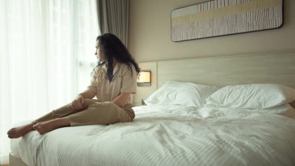 Utmattad Eller Uttråkad Sömnig Kvinna Sitter Sängen Tittar Genom Fönstret — Stockvideo