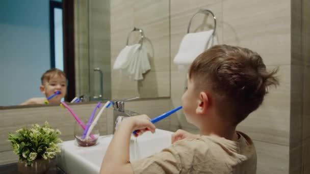 귀엽고 귀여운 어린이 화장실에서 이를닦고 미소짓는 아기의 일상적 집에서 거울보는 — 비디오