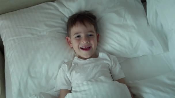 Retrato Menino Pequeno Alegre Engraçado Bonito Feliz Pijama Branco Acorda — Vídeo de Stock