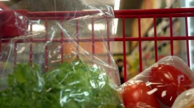 Markette el arabası süren bir kadın. Süpermarkette yakın çekim yiyecekleri olan bir araba konsept konsept ticaret alışveriş tramvayı alıcısı alışverişçi pazarı hipermarketi satın aldı