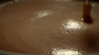 Kahve fincanını kapat, kahve bardağının üstünden yan görüş köpüklü köpüğü karıştır, kahveyi kaşıkla karıştır.
