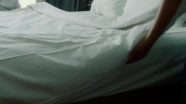 Çalışanlar, otelin iki hizmetçisi, müşteri odasındaki yatağı profesyonel olarak hazırlıyorlar. Beş yıldızlı otel konsepti ve kaliteli oda servisi. Kadınlar odadaki çarşafları değiştiriyor.