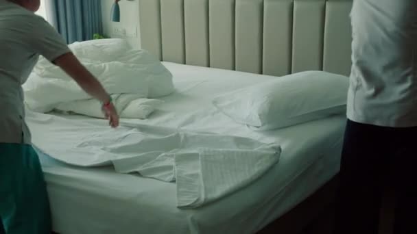 Çalışanlar Otelin Iki Hizmetçisi Müşteri Odasındaki Yatağı Profesyonel Olarak Hazırlıyorlar — Stok video