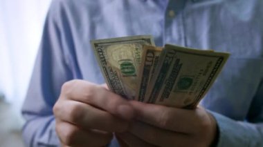 Amerikan Doları 'nın faturalarını sayan ya da nakit ödeme yapan eller. Yatırım, başarı, finansal beklentiler veya kariyer ilerlemesi kavramı.