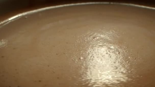 关上茶杯咖啡 从杯子上方侧面看咖啡 一个人的手搅动泡沫 用勺子搅拌咖啡 — 图库视频影像
