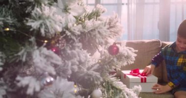 Mutlu şirin çocuk, sürprizle mutlu, Noel 'de hediyelerle dolu bir kutuyu açıyor. Güzel bir çocuğun portresi, içinde sürpriz bir Noel ruhu olan bir kutu açar, bayramlar ve kutlamalar.