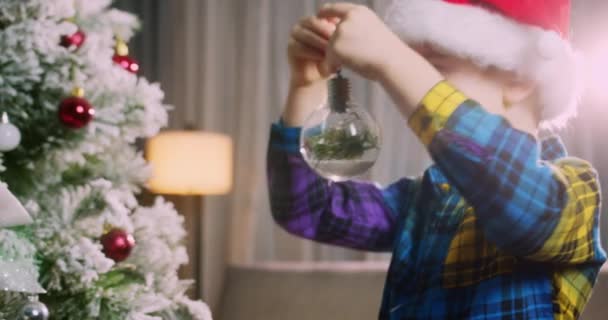 Счастливая Маленькая Девочка Украшает Рождественскую Елку Шарами Много Подарочных Коробок — стоковое видео