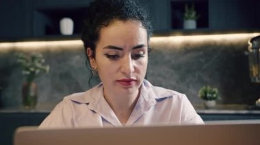 Kafkas asıllı kadın bir dizüstü bilgisayar üzerinde çalışıyor ofiste ya da ev mutfağında, dizüstü bilgisayar kullanıyor, bilgisayarla çalışıyor. Evde online iş kavramını kabul et