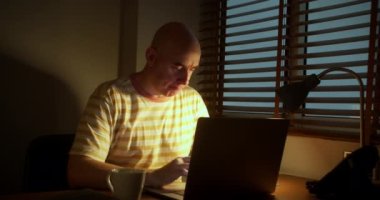 İş yerindeki erkek, laptopta çalışıyor ve abd kahve içiyor. Bilgisayarda fazla mesai yapan bir ofis çalışanı, internette çalışan bir iş adamı, dizüstü bilgisayarda çalışan bir iş adamı.