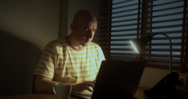 Adam ofiste ya da evde oturup dizüstü bilgisayarını kontrol ediyor. Harika haberler okuyor. Satış fiyatları iyi, kariyer promosyonu maaş artışı, online açık artırma kazananı parasal zafer kavramını kutluyor.