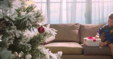 Mutlu şirin çocuk, sürprizle mutlu, Noel 'de hediyelerle dolu bir kutuyu açıyor. Güzel bir çocuğun portresi, içinde sürpriz bir Noel ruhu olan bir kutu açar, bayramlar ve kutlamalar.