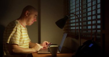 Kredi kartı tutan mutlu bir adam bankaya online ödeme yapıyor. İnternet mağazasında satın almak için laptop teknolojisi kullanan insan tüketicisi. Etrade web sitesi ödemeleri konsepti. Görüntüyü kapat.