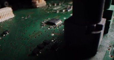 Makro kamera, bilgisayar ana kartı bileşenlerini, mikroçipi, işlemciyi ve transistörleri göstererek basılı devre kartının üzerinde yavaşça hareket ediyor. Elektronik cihazın içinde CIP 'li süper bilgisayar devreleri var.