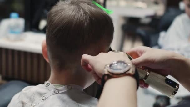 理发师把头发吹得干干净净的 时髦的理发师在理发店里用剪子剪掉小孩的头发 男人的发型和发型在沙龙里 用吹风机护理头发 — 图库视频影像