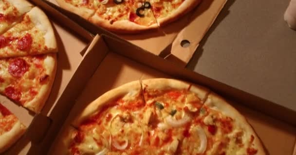 人間の手は オープンボックスから熱いおいしいイタリアのピザのスライスを取ります パーティーフードデリバリーサービス 友人は楽しみを持っています 一緒に食べ物を消費 閉じることを拒否 — ストック動画