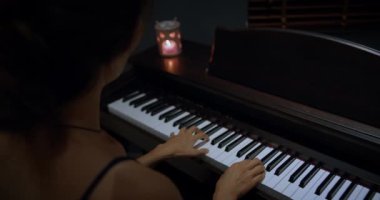 Kadın piyanist, güzel bir kuyruklu piyanoda hafif klasik müzik çalar. Bir eli yavaş çekimde. Piyano tuşları koyu renklerde kapanır. Öğrenci piyano çalmayı öğrenir.