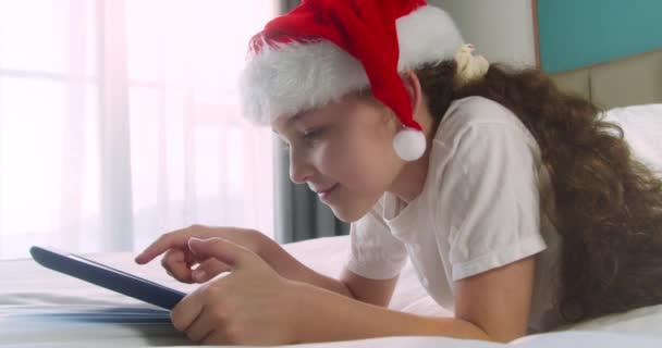 デジタルタブレットの子供 子供はクリスマスにオンラインビデオゲームを夢見ています デジタルタブレットネットワークでカバーの下でオンラインビデオを見ている娘の子供 ソーシャルメディアで — ストック動画