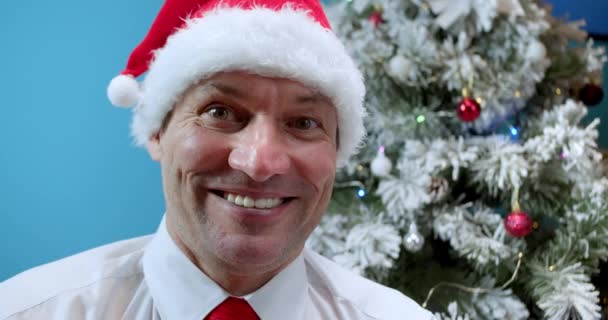 Close Van Een Lachende Man Een Kerstmuts Achtergrond Van Een — Stockvideo