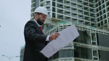 İnşaat mühendisi, denetçi, tasarımcı, müteahhit portresi bir inşaat sahasında, çok katlı binaların ne aşamada inşa edildiğini kontrol ediyor.