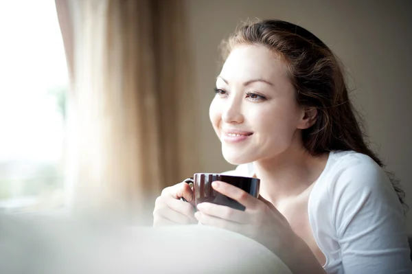 Asiática chica bebiendo té en la ventana — Foto de Stock