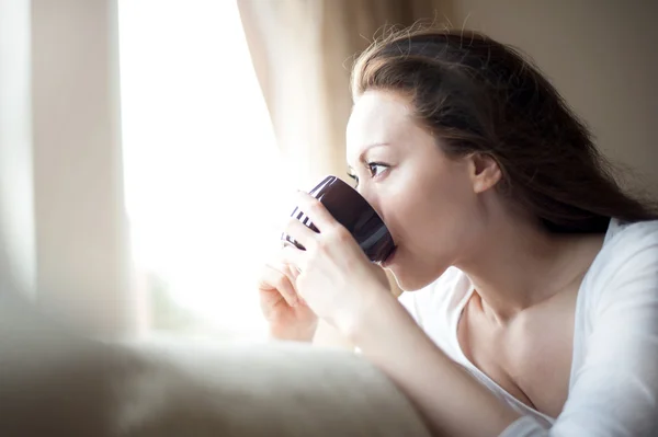 Asiática chica bebiendo té en la ventana Imagen de stock