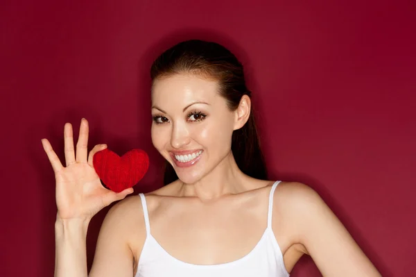 Pretty asian girl giving red heart