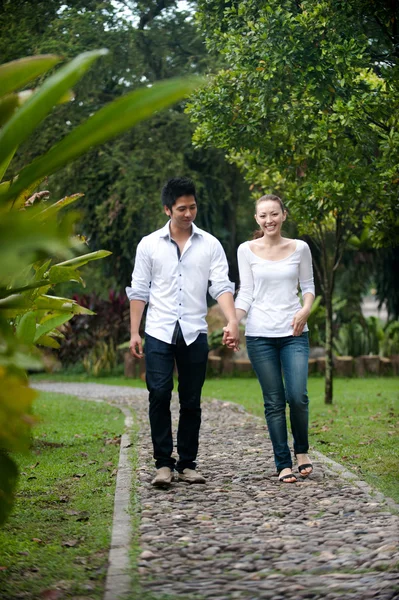 Pareja asiática cogida de la mano caminando por el camino del parque — Foto de Stock