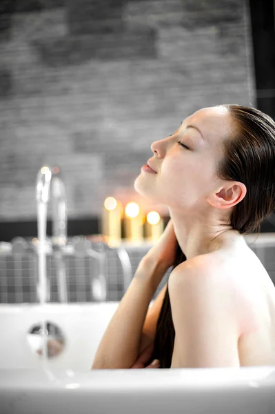 Vonzó vegyes ázsiai női pihenés, és élvezi a hajat mosni a fürdőben — Stock Fotó