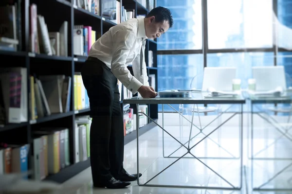 Азиатский бизнесмен стоит на своем рабочем месте — стоковое фото