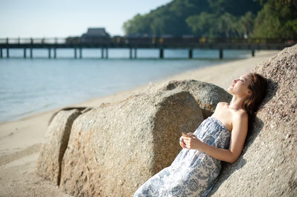 Привлекательная азиатская женщина лежит на скале — стоковое фото