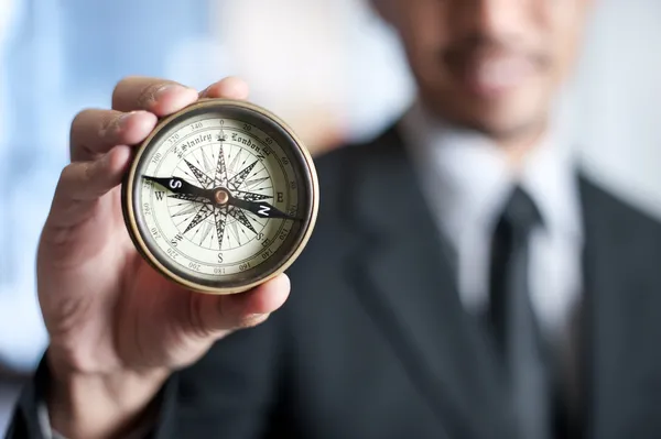 Empresario sosteniendo una brújula — Foto de Stock