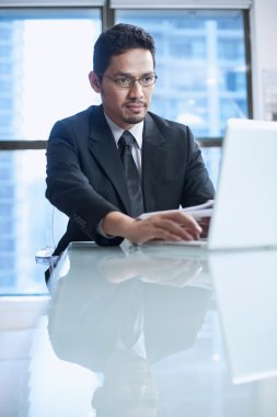 onun işyerinde laptop ile oturan işadamı