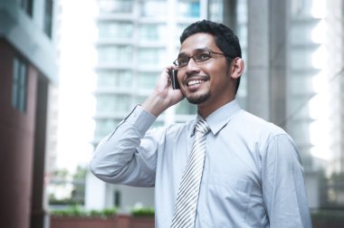 cep telefonuyla konuşurken gülümseyen iş adamı