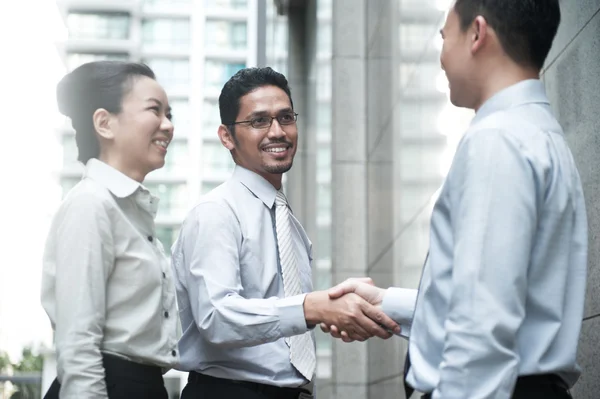 Empresários sorridentes apertando as mãos — Fotografia de Stock