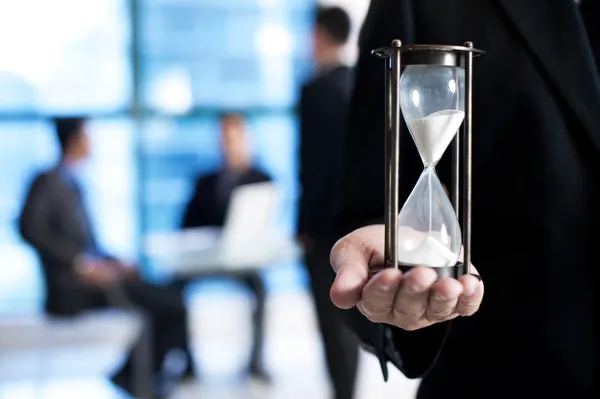 Primer plano del hombre de negocios de la mano sosteniendo reloj de arena . —  Fotos de Stock