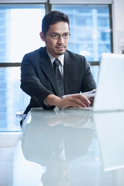 Бізнесмен сидить на своєму робочому місці з ноутбуком Стокове Фото
