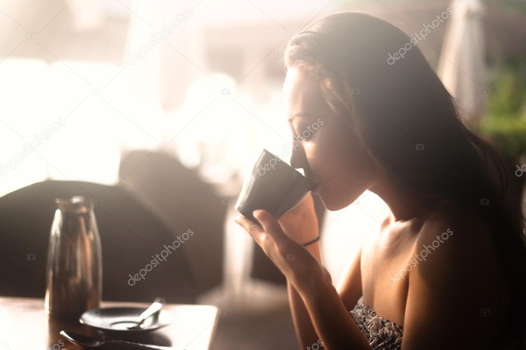 Attractive Asian Female drinking from a cup