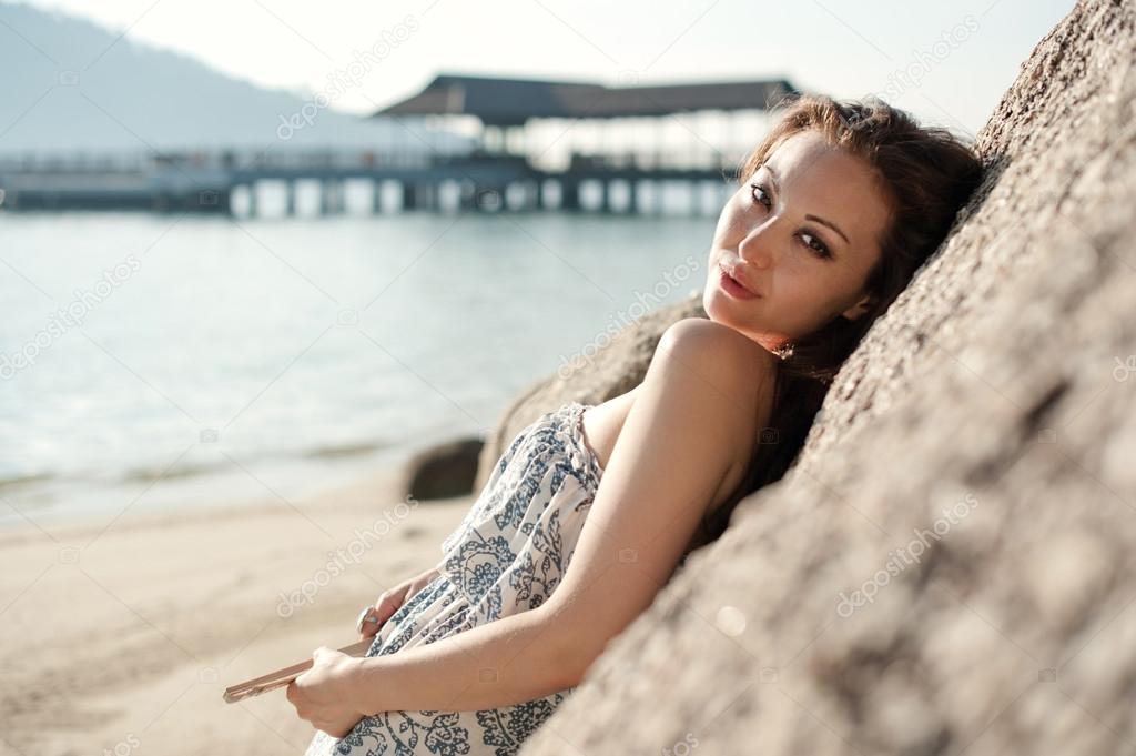 Attractive Asian Female leaning on a rock