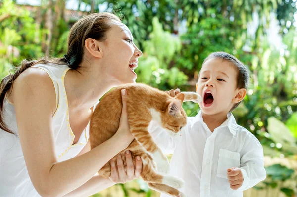Aasian äiti pojan ja kissan kanssa kuvapankin valokuva