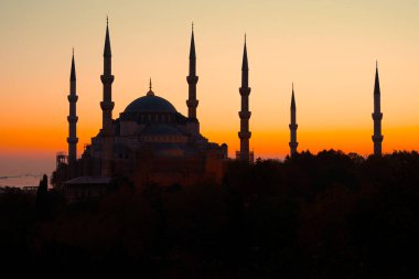 Sarı günbatımında İstanbul 'daki mavi cami. Mavi Cami ya da Sultanahmet Camii ve minareler parlak sarı gökyüzüne karşı
