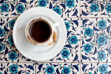 Artan kahve, tortu, seramik beyaz fincanda koyu Türk kahvesi, üst manzara.