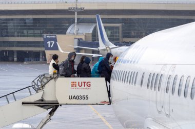 MOSCOW - OCT 19: People on a ladder before flight during cold autumn day at Vnukovo Airport in Moscow, October 19. 2021 in Russia