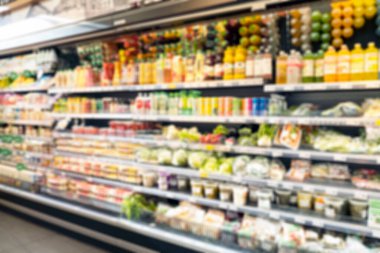 Raflarda yiyecek ve odağını kaybetmiş bir marketin bulanık arka planı.