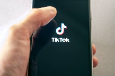 BERLIN - 11 Şubat: 10 Şubat 'ta Berlin' de Tiktok logotype ekranında cep telefonu tutan kişi. Almanya 'da 2022
