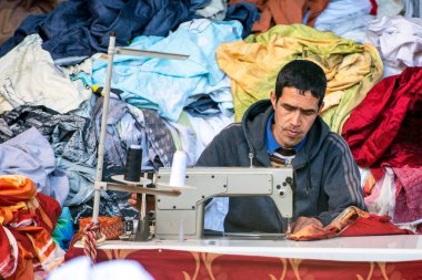 ESSAOUIRA - JAN 03: Man worker sewing clothes at an oriental street market in Medina district in Essaouira, January 03. 2018 in Morocco